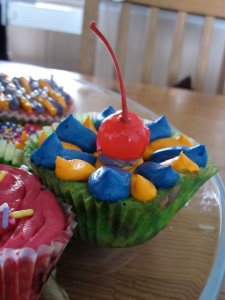 Muffins skreitt með smjörkremi (lituðu)og koktelberi